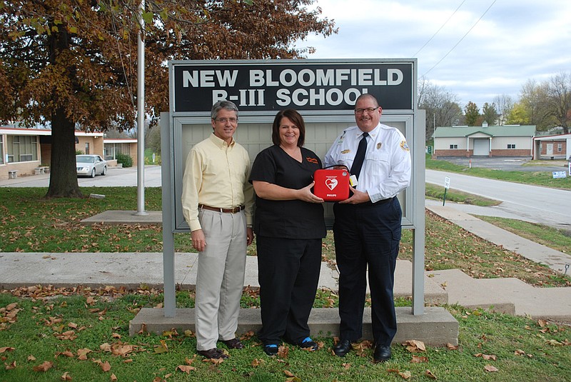 Callaway Ambulance District Director Charlie Anderson, right, presents New Bloomfield School District Superintendent David Tramel and School District Nurse Tima Goodnight with an Automatic External Defibrillator on behalf of the ambulance district. The devices are used to automatically diagnose certain life-threatening heart problems and administer shock if needed.