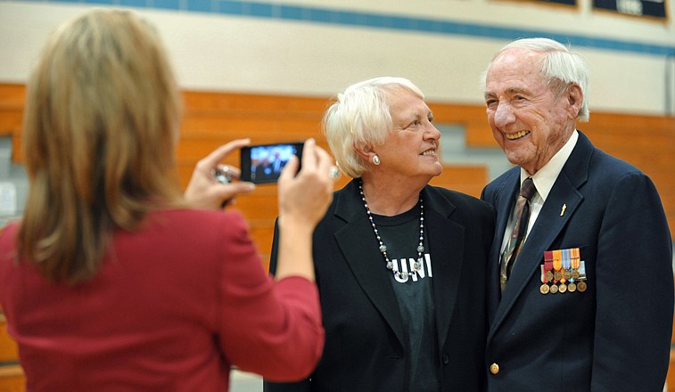 Sarah Hill uses her phone to photograph Linda and Bill McAnany after a Veterans Day Appreciation Assembly at Helias Catholic High School. Several local veterans, including McAnany, were on hand to be celebrated during the event Thursday morning. The school also presented a check for more than $700 to him to help defray shipping expenses in support of Operation: Guardian Angel. 