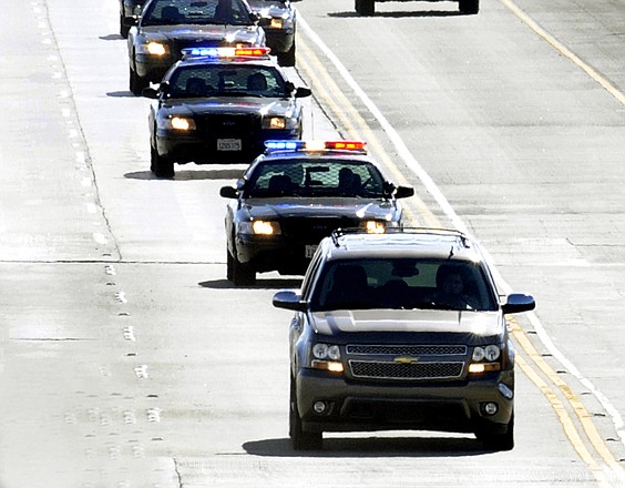 Los Angeles County Sheriff's Department patrol cars follow a bank robbery suspect Friday in a Chevrolet Suburban on the Antelope Valley Freeway in Palmdale, Calif. The bank robbery suspect was cornered on an Antelope Valley street and shot to death Friday on live television.