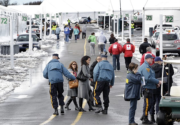 New Jersey Commissioner of the Department of Human Services, Jennifer Velez, center, walks near rows of large tents Thursday in Oceanport, N.J., as she tours the area. New Jersey is moving some Superstorm Sandy evacuees from tent-like housing at Monmouth Park, a racetrack, to shelters after it appears the tents were too big for the small number of evacuees.