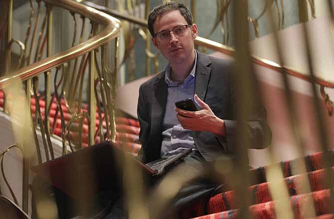 Nate Silver holds his phone as he sits on the stairs with his laptop computer at a hotel in Chicago on Friday, Nov. 9, 2012. The 34-year-old statistician, unabashed numbers geek, author and creator of the much-read FiveThirtyEight blog at The New York Times, correctly predicted the presidential winner in all 50 states, and almost all the Senate races.