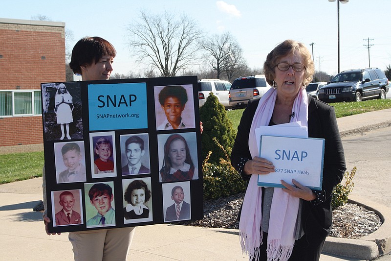 Lori Black of CARDV holds a sign of abuse victims while SNAP Midwest Associate Director Judy Jones, right, speaks at a press event Wednesday in front of the Callaway County Sheriff's Office. SNAP believes that a convicted sex offender, Gerald Howard, worked as a counselor during the '80s in Fulton, and urged anyone who knows when and where he worked to contact the authorities.