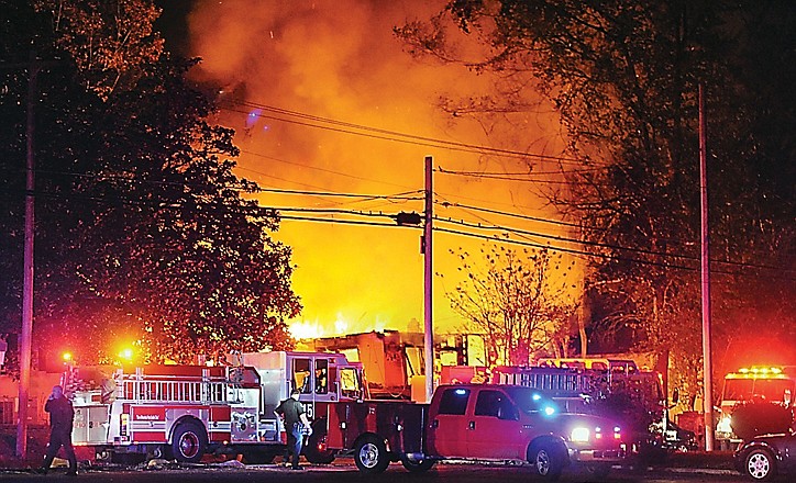 Flames and smoke billow from a home in west Jackson, Miss., after a small plane carrying three people crashed into the residence.