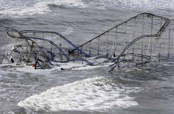 In this Wednesday, Oct. 31, 2012 file photo, waves wash over a roller coaster from a Seaside Heights, N.J. amusement park that fell in the Atlantic Ocean during Superstorm Sandy. Superstorm Sandy, the rare and devastating Northeast storm, and an election that gave Democrats gains have put consideration of global warming back in the picture.