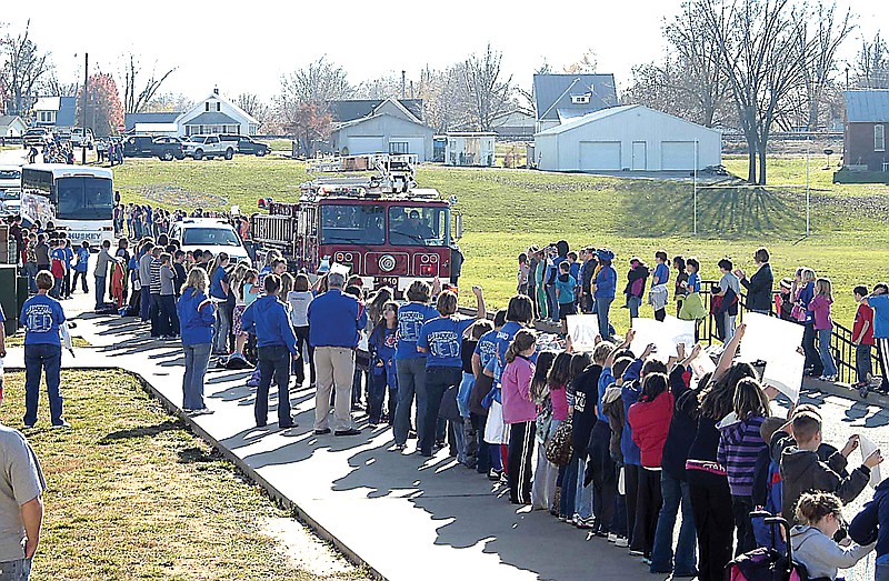 The Pinto football team receives a send off from young Pinto fans as there bus, led by the firetruck and police escorts, rolled down the street.