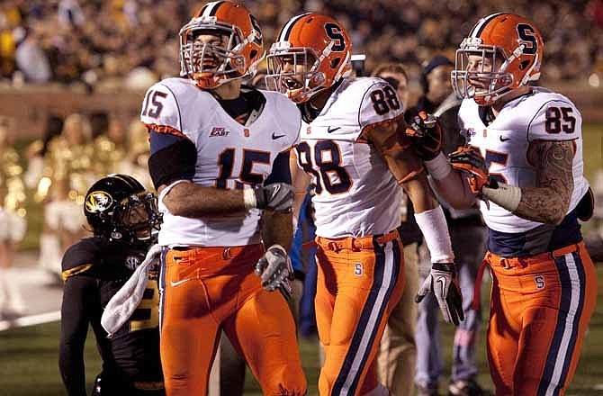 Syracuse's Alec Lemon, top left, celebrates with teammates Jarrod West, center, and Beckett Wales, right, after Lemon scored a touchdown past Missouri's E.J. Gaines, bottom, left, during the second half of an NCAA college football game, Saturday, Nov. 17, 2012, in Columbia, Mo. Syracuse won the game 31-27.