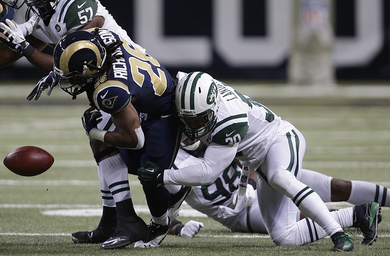 Rams running back Daryl Richardson (left) fumbles the ball as he is hit by Jets free safety LaRon Landry (right) during the fourth quarter Sunday in St. Louis. New York's Garrett McIntyre recovered the fumble.