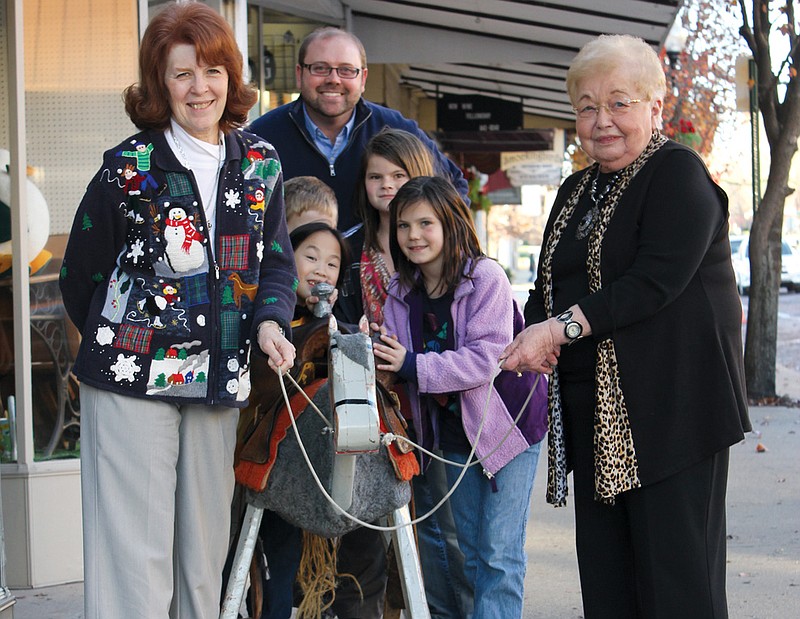 From left: Barb Huddleston, Alaina  McCray, Cody McCray, Jody Paschal, Rylee McCray, Ellie McCray and Helen Gidley lead Smokey the Horse from Gidley's Shoe Store to  his new "stable," the Kingdom of Callaway Historical Society Museum. Smokey is believed to be more than 85 years old and has been a fixture in Fulton's downtown shoe stores over the decades.