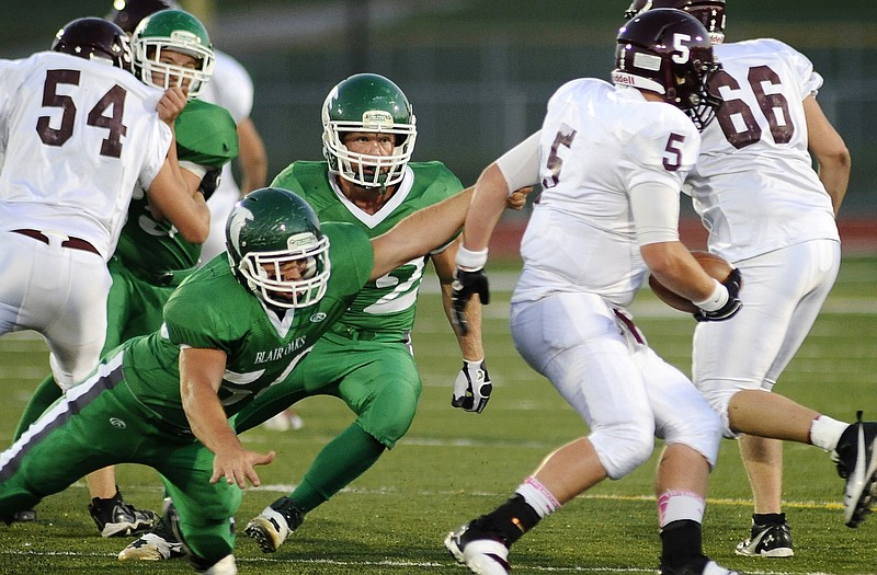 Blair Oaks teammates Hayden Haney (left) and Derek Otto (center) close in on School of the Osage quarterback Bo Dean during a game this season at the Falcon Athletic Complex. Haney and Otto were both Class 2 all-district selections on defense.