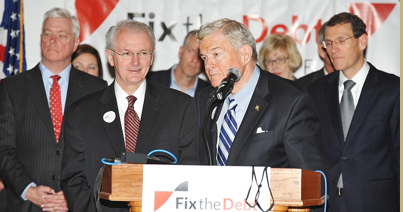 Former U.S. Sen. Christopher "Kit' Bond listens to a reporter's question Monday during a press conference to kick off the "Fix the Debt" Missouri campaign. Standing behind him, from left, are: Lt. Gov. Peter Kinder; former Gov. Bob Holden and state Treasurer Clint Zweifel.