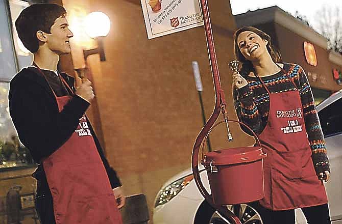 Helias students Brett Kempker, left, and Bethany Berhorst stand outside Schnucks while volunteering as bell ringers at a Salvation Army donation pot.