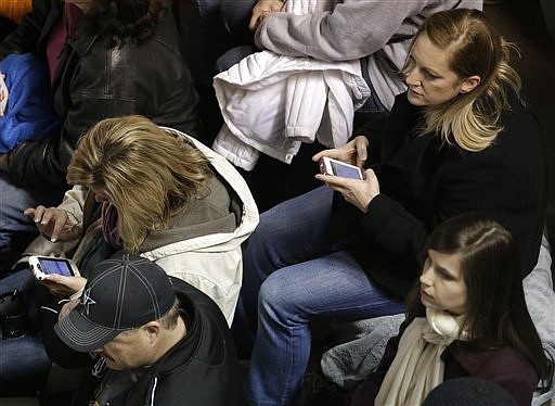 In this Nov. 17, 2012, photo, fans use their cell phones during an NCAA college football game between Vanderbilt and Tennessee in Nashville, Tenn. The Southeastern Conference understands that connectivity with fan devices is a hot-button issue, and the need for more bandwith is being studied by a fan experience group approved by SEC school presidents and chancellors earlier this year. 