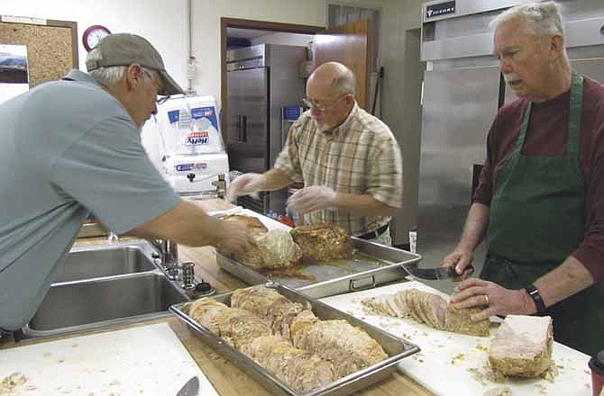 From left, Fred Mackay, Steve Whitlock and Brian Stanton carve turkey Tuesday in preparation for First Baptist Church's community Thanksgiving dinner. The annual event will serve about 450 people from 11 a.m. to 1 p.m. Thursday.