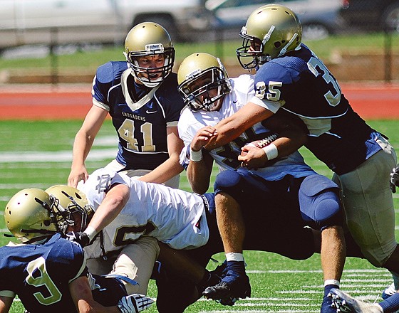 
Helias linebacker Justus Schulte wraps up and takes down Quincy Notre Dame running back Nick Weiman at the line of scrimmage during a September game at Adkins Stadium. Schulte has 202 total tackles this season heading into today's Class 4 state championship game against Webb City at the Edward Jones Dome.