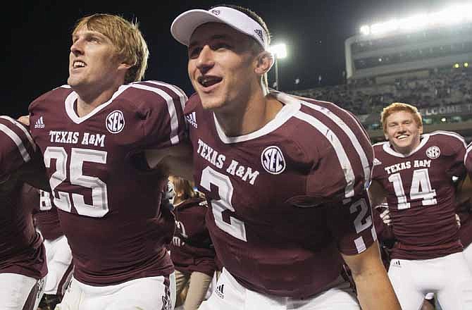 Texas A&M quarterback Johnny Manziel (2) sings the Aggie War Hymn with Ryan Swope (25) and Conner McQueen (14) after an NCAA college football game against Missouri, Saturday, Nov. 24, 2012, in College Station, Texas. A&M defeated Missouri 59-29.