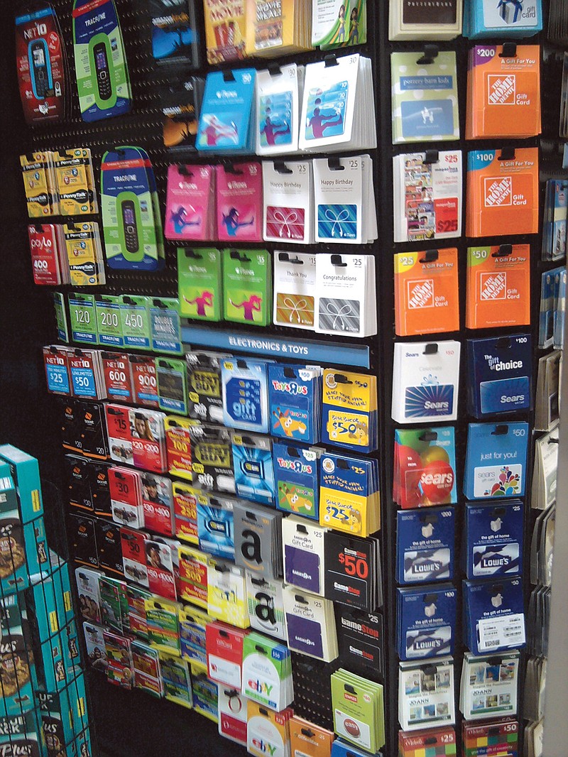 A grocery store rack displays dozens of brands and denominations of gift cards.