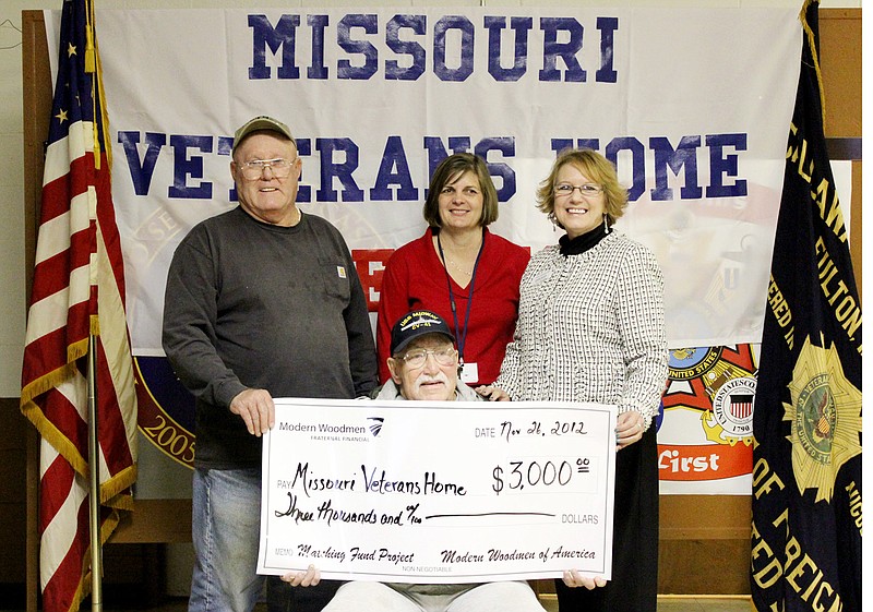 Larry Underwood, senior vice commander of Veterans of Foreign Wars Post 2657 of Fulton, left, presents a $3,000 check Monday to the Missouri Veterans Home in Mexico, Mo. From left standing are Susan Paden, supervisor of volunteer services at the Veterans Home in Mexico and Janette Vomund, representative of Modern Woodmen of America. The organization matched the funds raised by veterans groups. Seated is Frank Kramer of Mexico, a resident of the home for the last year.