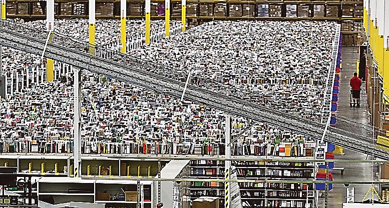 An employee walks a wide isle at Amazon.com's 1.2 million square foot fulfillment center in Phoenix.