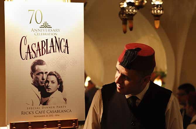 A Rick's Cafe's server looks at the poster announcing the 70th anniversary tribute to the 1942 movie "Casablanca", in Casablanca, Morocco, Saturday, Nov. 24, 2012. A former U.S. diplomat spent two years of work and a million dollars in investments to bring Rick's Cafe to Morocco's largest city. The elegant nightclub where Humphrey Bogart pined for Ingrid Bergman was just a set on a Warner Bros. sound stage in California; the film crew never got anywhere near North Africa.