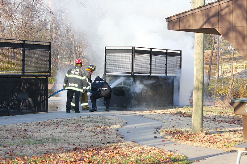 Fulton Fire Department personnel extinguish a blaze beneath a ramp at Fulton Skate Park Thursday afternoon.