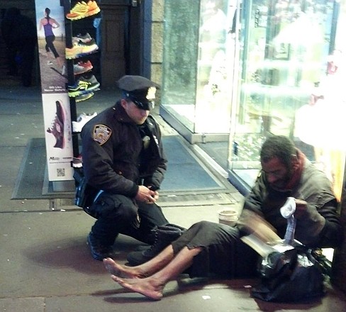 New York City Police Officer Larry DePrimo presents a barefoot homeless man in New York's Time Square with boots on Nov. 14. Jennifer Foster was visiting New York when she came across the shoeless man asking for change in Times Square. As she was about to approach him, she said, the officer came up to the man with a pair of all-weather boots and thermal socks on the frigid night. 