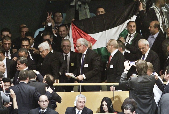 A Palestinian flag is displayed as Palestinian President Mahmoud Abbas leads his delegation from the U.N. General Assembly after a vote recognizing Palestine as a state on Thursday.