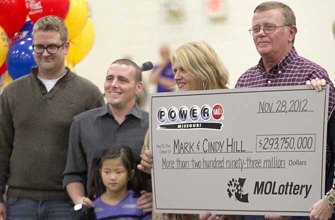 Mark and Cindy Hill hold a Powerball check with their three of their four children, Jarod, left, Cody and six-year-old Jaiden in Dearborn, Mo., Friday, Nov. 30, 2012.