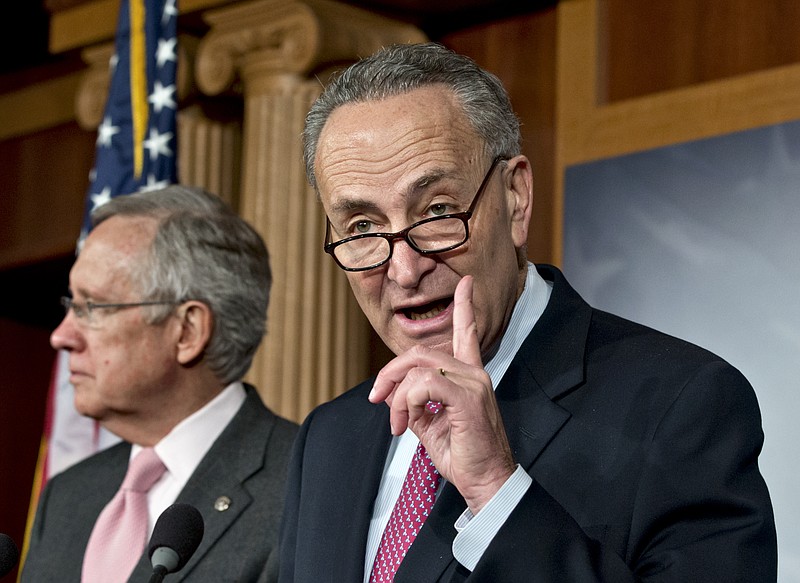 Sen. Charles Schumer, D-N.Y., right, accompanied by Senate Majority Leader Harry Reid of Nevada, gestures Thursday during a news conference on Capitol Hill in Washington after talks with Treasury Secretary Timothy Geithner on the fiscal cliff negotiations.