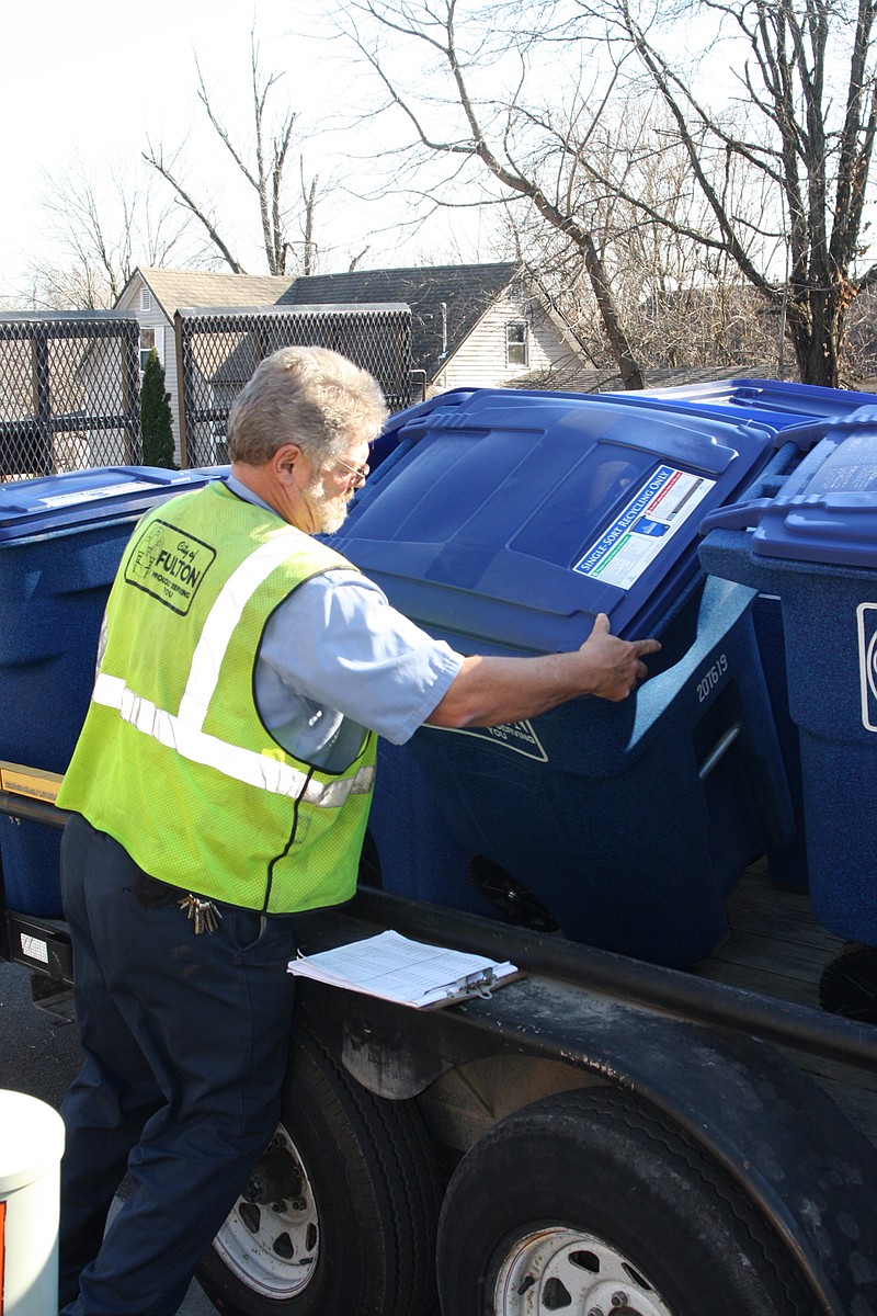 City worker Cal Luckett unloads a recycling cart to distribute on 6th Street Friday. Homes that signed up for the program received the carts throughout the day. Pickup will start next week with their regular trash.