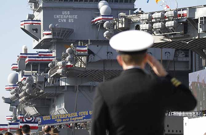 A Navy officer salutes during the inactivation ceremony for the first nuclear powered aircraft carrier USS Enterprise at Naval Station Norfolk Saturday, Dec. 1, 2012 in Norfolk, Va. The ship served in the fleet for 51 years.