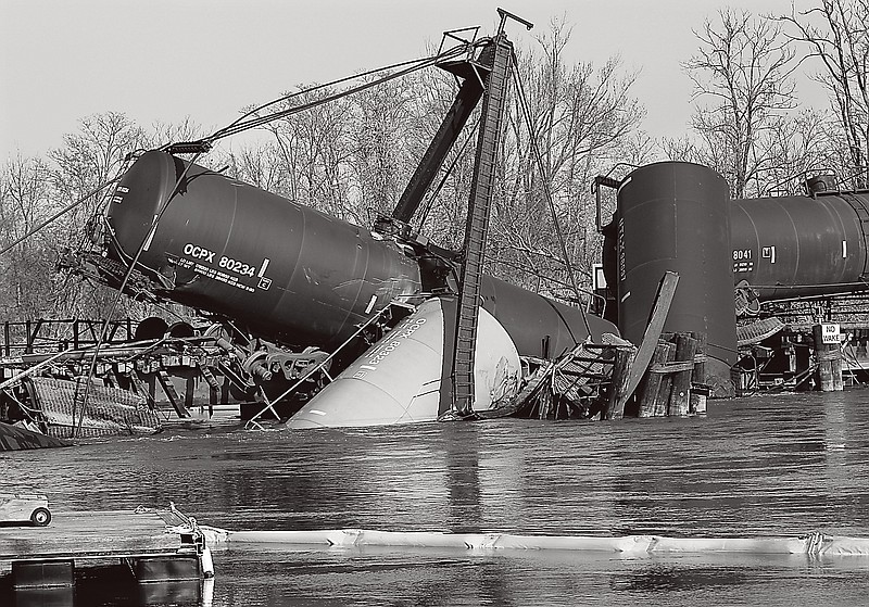 A containment boom floats in Mantua Creek near freight train tank cars that derailed Friday in Paulsboro, N.J.