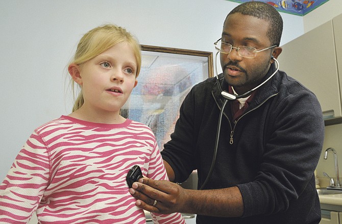 
Dr. Albert Johnson listens to the chest and lungs as seven year old Jeana Abbott takes deep breaths for him to see what is the cause of her discomfort is. Johnson is with JCMG Pediatrics.