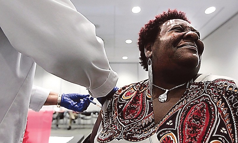 Elizabeth Saint Victor winces as she gets a free flu shot from LPN Jean Buck courtesy of Baptist Healthcare in Memphis, Tenn., at the Central Library. 
