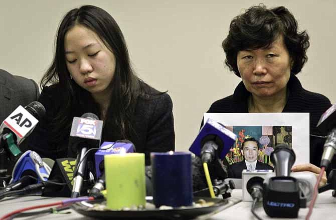 Serim Han , right, holds a picture of her husband Ki-Suck Han as she sits next to their daughter Ashley Han, 20, during a news conference on Wednesday, Dec. 5, 2012 in New York. A homeless man was arrested Wednesday in the death of Ki-Suck Han, who was pushed onto the tracks and photographed just before a train struck him. 