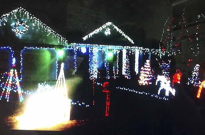 People are parking and dancing in the street at the Holtmeyer's Jock Jams & Gangnam Style Christmas Light Display at 3023 Mercedes Lane (off Schumate Chapel Road). A YouTube video of the display (screenshot above) accompanies this article.