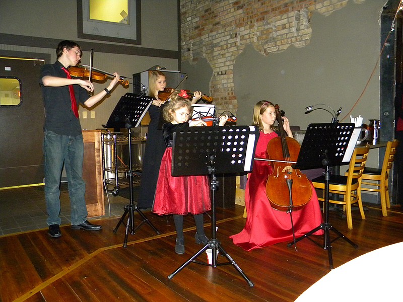 The Keithahn family plays a melody to serenade diners and bidders during the Holiday Dinner fundraiser at Beks Restaurant for Our House Sunday. The fundraiser event brought in $10,000 for the organization, which operates two homeless shelters in Fulton.                               