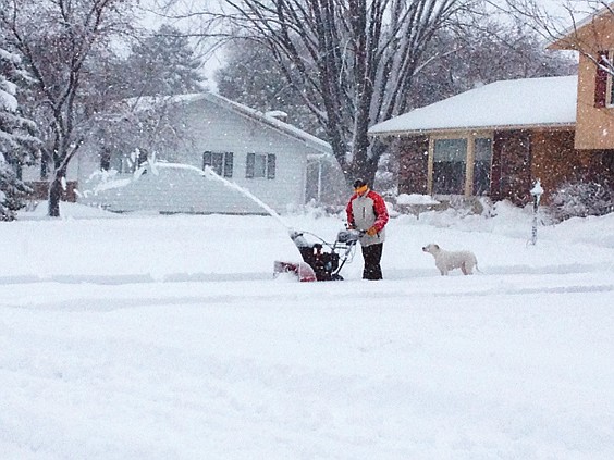 A Willmar, Minn., man blows snow to clear his driveway during the first major snow storm of the season.