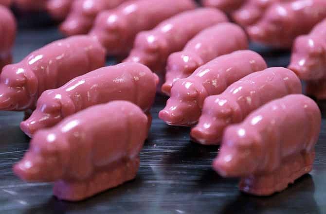 In this Dec. 6, 2012, photo, peppermint pigs are lined up after being removed from a mold at Saratoga Sweets in Halfmoon, N.Y. A holiday tradition in upstate New York has a peppermint twist: pig-shaped hard candies are sold with little metal hammers to be smashed at Christmas. 