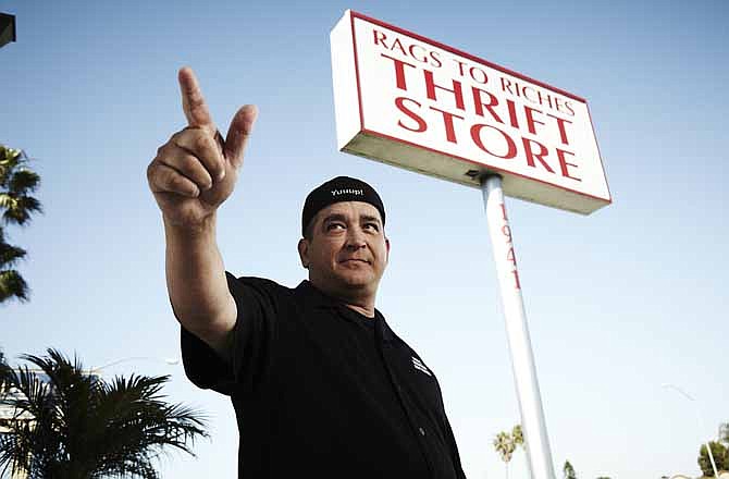 This 2011 photo released by A&E shows Dave Hester in front of the Rags to Riches thrift store in Costa Mesa, Calif. Hester sued A&E Television Networks on Tuesday, Dec. 11, 2012, claiming he was fired from the show after complaining that producers had planted valuable items in some of the lockers featured on the reality series.