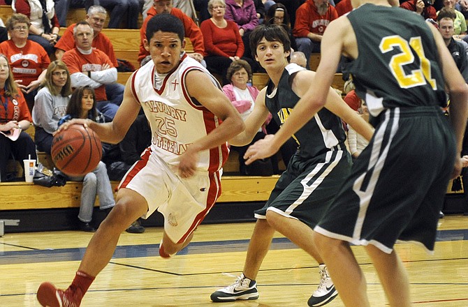 Calvary Lutheran's Loren Schlichting drives to the basket around a pair of defenders from the Fulton School at St. Albans on Friday night at Trinity Lutheran. The Lions lost 51-49.