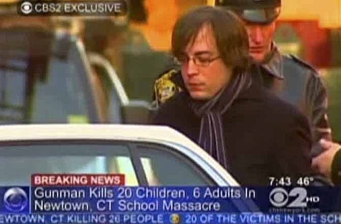 In this frame grab provided by WCBS in New York, Ryan Lanza, the 24-year-old brother of Sandy Hook Elementary School shooter Adam Lanza, is escorted by police into a cruiser in Hoboken, N.J., Friday, Dec. 14, 2012. Adam Lanza, 20, killed his mother at home and then opened fire Friday inside the elementary school where she taught, massacring 26 people, including 20 children, as youngsters cowered in fear to the sound of gunshots echoing through the building and screams coming over the intercom. (AP Photo/WCBS-TV) 