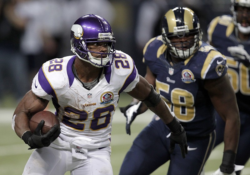 Minnesota Vikings running back Adrian Peterson, left, runs past St. Louis Rams outside linebacker Jo-Lonn Dunbar on his way to a 52-yard gain during the fourth quarter of an NFL football game Sunday, Dec. 16, 2012, in St. Louis.