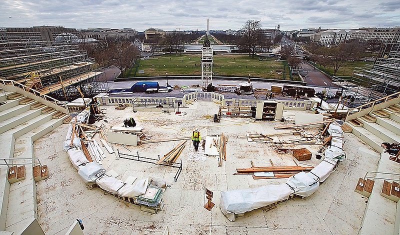 Construction workers continue work on the platforms on the west side of the Capitol where dignitaries and news cameras will witness the inaugural ceremonies.