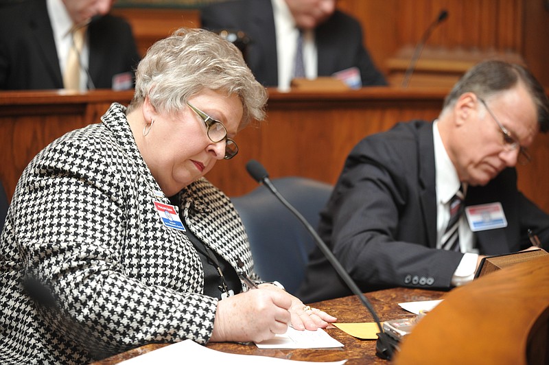 Penny Quigg writes in her vote as one of 10 electors in Missouri's electoral college to meet at the Capitol Monday to cast their votes. Quigg, from Jefferson City, represents the 3rd Congressional District. Next to Quigg is Stanley Cox from the 4th District. 