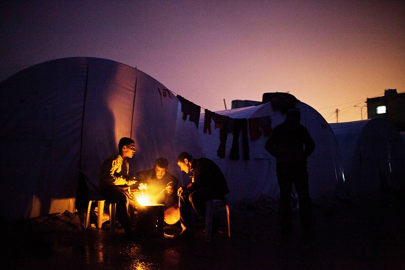 Syrians warm themselves at a refugee camp in Azaz, Syria, on Monday. Thousands of Syrian refugees who fled their homes due to fighting between Free Syrian Army fighters and government forces, face cold weather as temperatures dropped to 2 degrees Celsius (36 degrees Fahrenheit) in Azaz. 