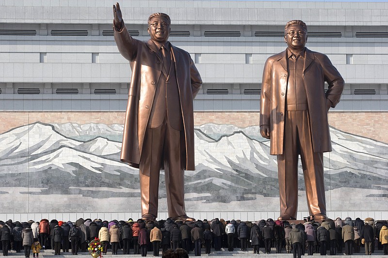 North Koreans bow before the statues of late leaders, Kim Il Sung, left, and Kim Jong Il, at Mansu Hill in Pyongyang, North Korea, on Monday. Sirens wailed for three minutes at noon Monday in honor of the first anniversary of the death of Kim Jong Il. 