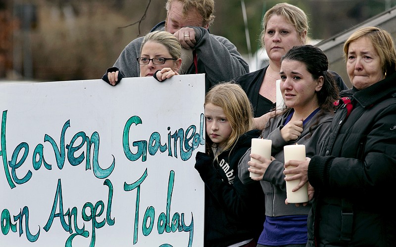 Tom Doyle, back left, stands with family and co-workers and wipes his face as the funeral procession for 6-year-old James Mattioli passes by Tuesday as it approaches St. John's Cemetery. Mattioli died in the Sandy Hook Elementary School shootings.