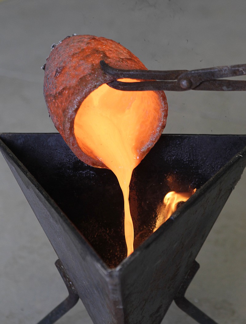 Sutter Gold Mining Company mill superintendent Paul Skinner pours the first thin stream of glowing molten gold into a mold, forming a shiny one-inch pyramid near Sutter Creek, Calif. 