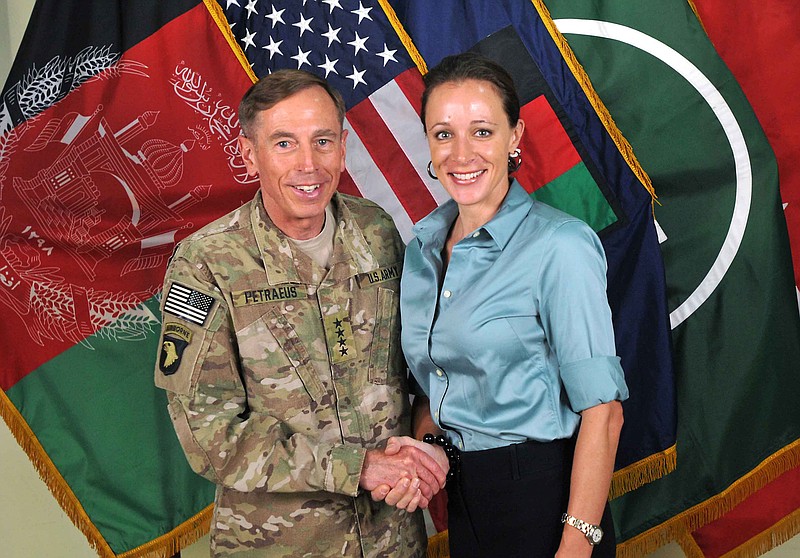 The former Commander of International Security Assistance Force and U.S. Forces-Afghanistan Gen. Davis Petraeus, left, shakes hands with Paula Broadwell, co-author of  "All In: The Education of General David Petraeus."  The Justice Department is dropping its investigation of David Petraeus' mistress, Paula Broadwell, into whether she stalked a romantic rival online.