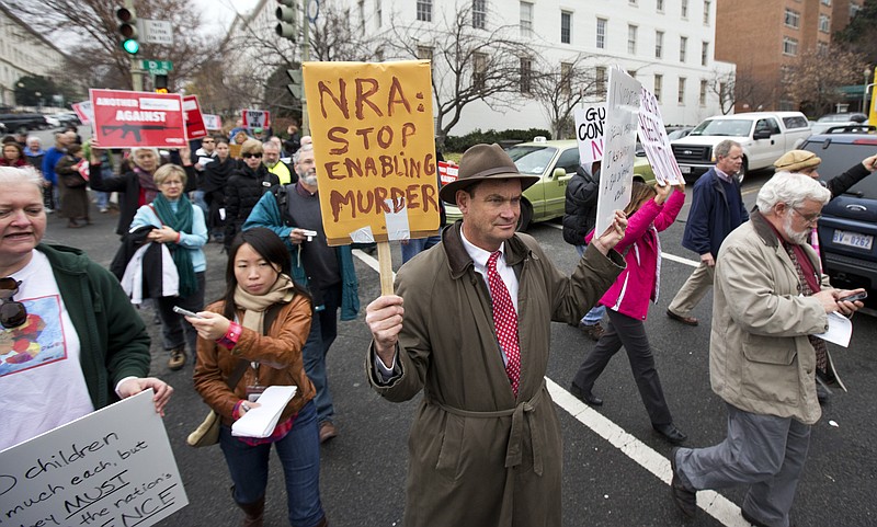 Patrick Hand, center, joins a march to the National Rifle Association headquarters Monday on Capitol Hill in Washington. Curbing gun violence will be a top priority of President Barack Obama's second term, aides say, but exactly what he'll pursue and how quickly are still evolving.
